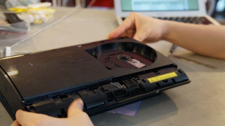 PS3 Super Slim being opened on the repair bench